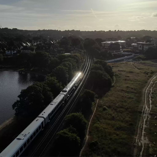 Aerial drone footage of a South Western Railway train traveling through Poole Park, Dorset. Shot for film and television production.