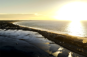 Aerial view of Sandbanks, Dorset, at dawn, showing the coastline and beach.